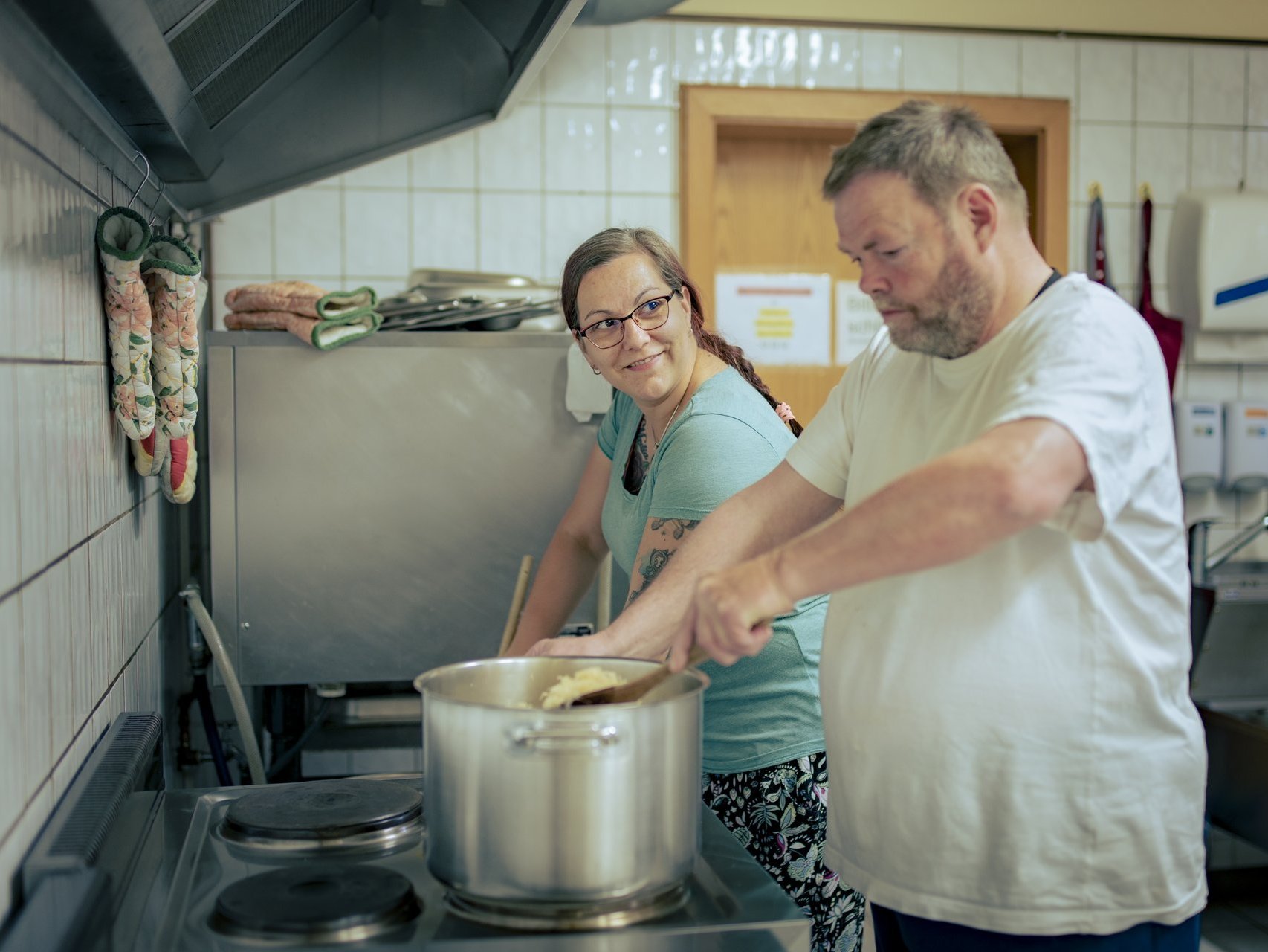 Zwei Personen sind in der Küche und kochen. 