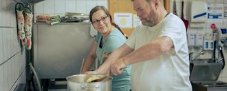 Zwei Personen die in der Küche kochen. 