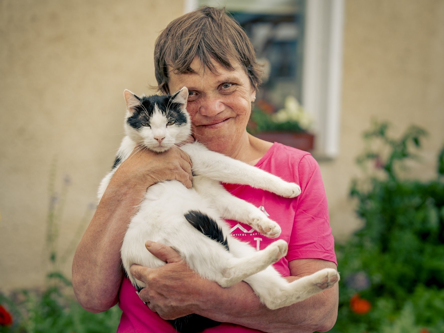Eine Person die eine Katze trägt 
