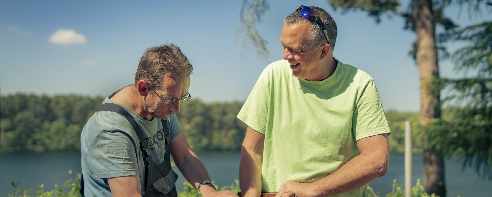 Therapeut und Person mit Suchterkrankung arbeiten im Sonnenschein im Haus am See